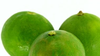 Yeşil limonun 4K dönüşü. Üst manzara, 360 derece döndürme, limonu kesme..