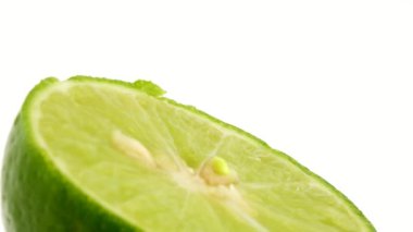 Yeşil limonun 4K dönüşü. Üst manzara, 360 derece döndürme, limonu kesme..