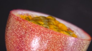 Gözbebeği tutkusunun 4K çapraz kesiti. Kesilmiş taze egzotik tutku meyvesi Macro shot 'ı. Siyah arka planda izole edilmiş.