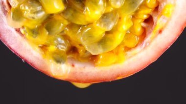 4K çapraz kesitli bir öğrenci tutkusu meyvesi Macro shot taze, egzotik tutku meyvesi siyah arka planda izole
