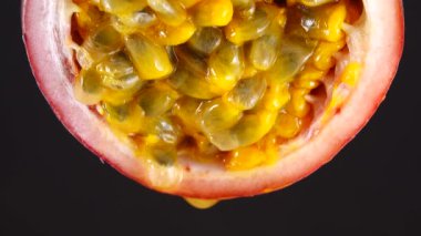 4K çapraz kesitli bir öğrenci tutkusu meyvesi Macro shot taze, egzotik tutku meyvesi siyah arka planda izole