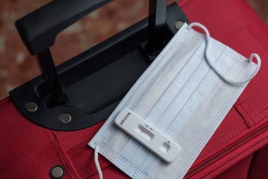 Negatif antijen testi, yüz maskesi ve bagaj. Covid ve seyahat kavramı