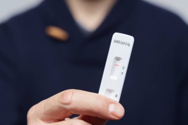 Negatif bir antijen hızlı testini tutan el.