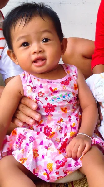 Cute tersenyum gadis dalam gaun bergaris merah muda, gadis berusia 5 bulan, gadis Asia — Stok Foto