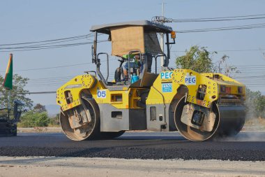 Phayao, Tayland - 27 Ocak 2021: Asfalt Yolu 'ndaki Zoom Back View Worker ve Road Roller
