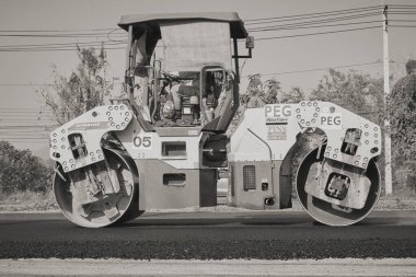 Phayao, Tayland - 27 Ocak 2021 Zoom Side View Black and White Worker ve Road Roller on Asphalt Road