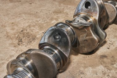 Beton zemin üzerinde Motor yağı lekesi olan Kırık Krank milini görüntüle