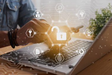 Casual Businessman Hand Touching Mobile Phone or Smart Phone Screen and Hexagon Unlock Security Sign and Laptop Computer. Secure or Firewall and Protection Concept