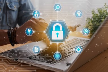 Casual Businessman Hand Touching Mobile Phone or Smart Phone Screen and Blue Center Hexagon Lock Security Sign and Laptop Computer. Secure or Firewall and Protection Concept