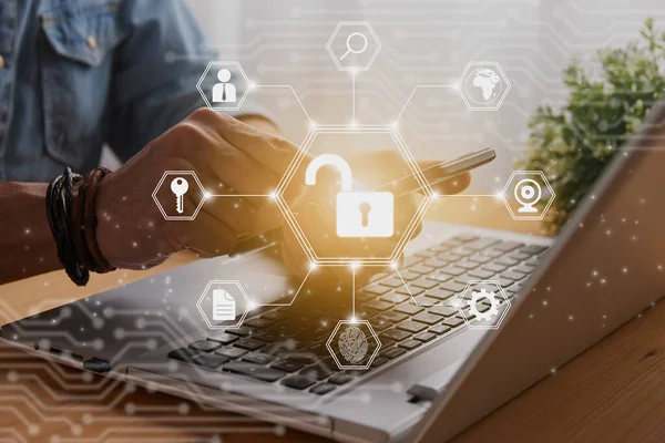 Casual Businessman Hand Touching Mobile Phone or Smart Phone Screen and Hexagon Unlock Security Sign and Laptop Computer. Secure or Firewall and Protection Concept