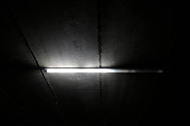 Yarım veya yarı hasarlı LED T8 floresan. Yeraltı otoparkındaki lamba gibi.