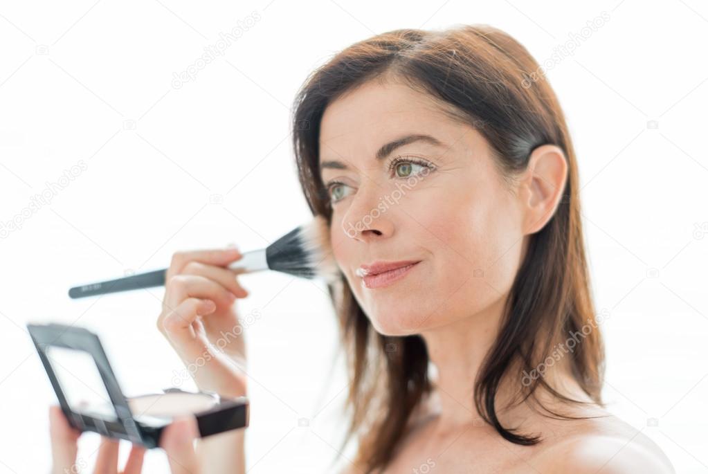 Woman in her forties applying makeup
