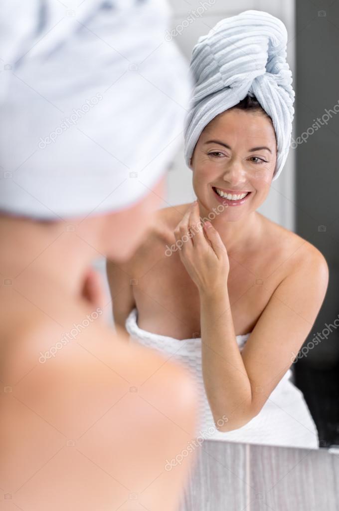 Middle aged woman looking at herself in the mirror
