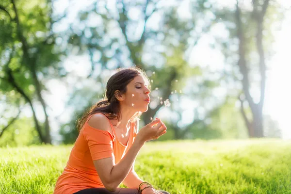 Portrait of girl in nature blowing a dandelion — Stock Photo, Image
