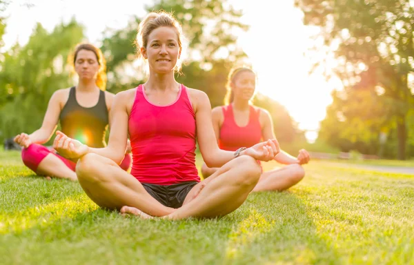Kvinnor gör yoga utomhus vid solnedgången — Stockfoto