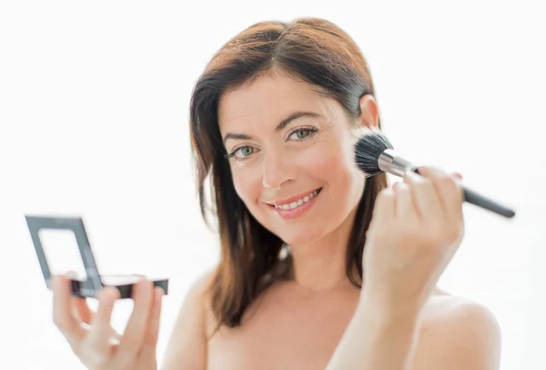 Mujer atractiva en sus cuarenta años aplicando maquillaje —  Fotos de Stock