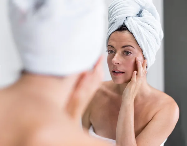 Orta yaşlı kadın kendini aynaya bakıyorum