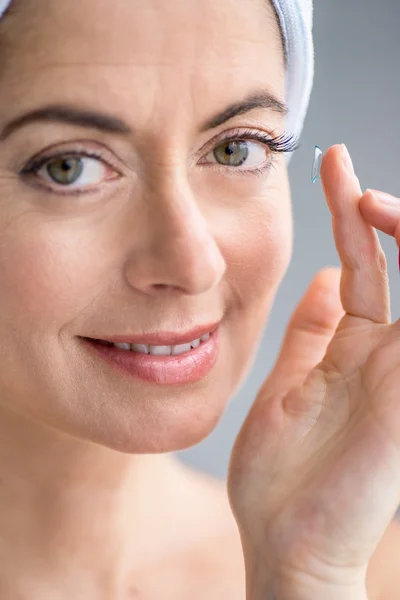 Mulher em seus quarenta anos inserindo lentes de contato — Fotografia de Stock