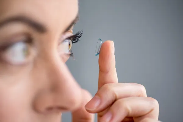 Kvinnan i hennes fyrtiotalet infoga kontaktlinser Stockfoto