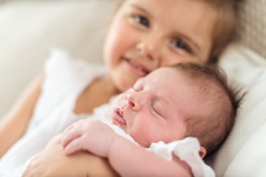 Ablasının kollarında uyuyan bebek