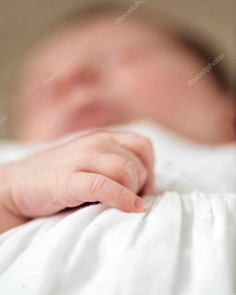 Hand detail of a sleeping newborn baby girl