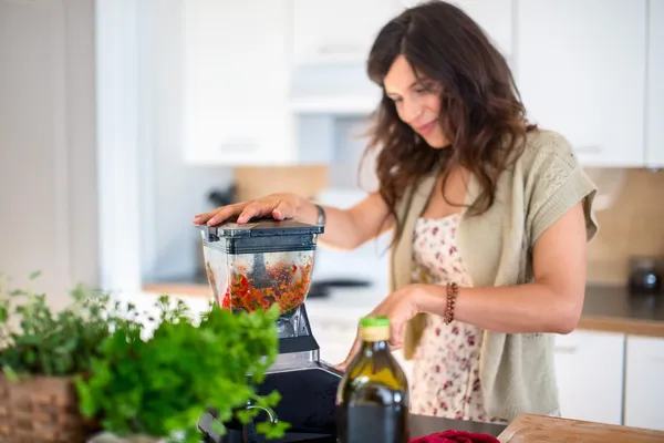 Health conscious woman using a blender — Stock Photo, Image