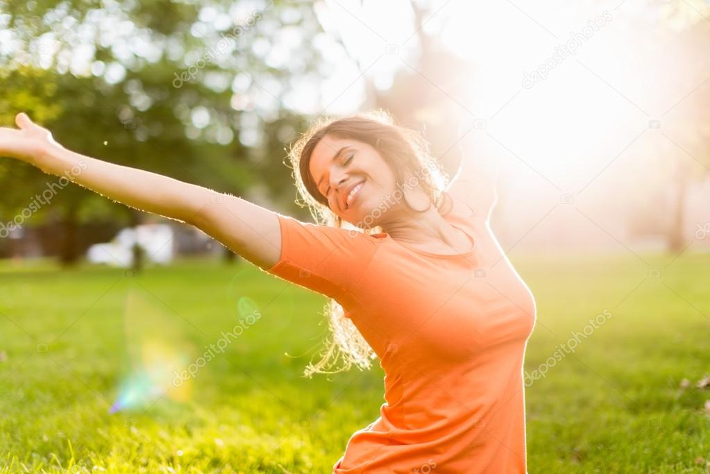 Active woman doing yoga poses in a sun flare