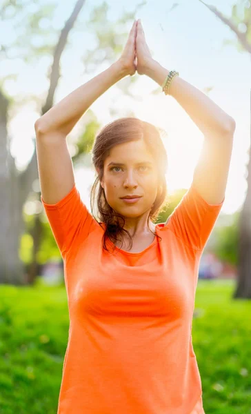 Active woman doing yoga poses in a sun flare — Stock Photo, Image