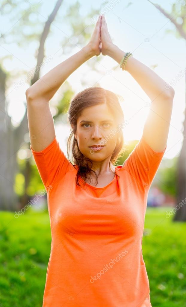 Active woman doing yoga poses in a sun flare