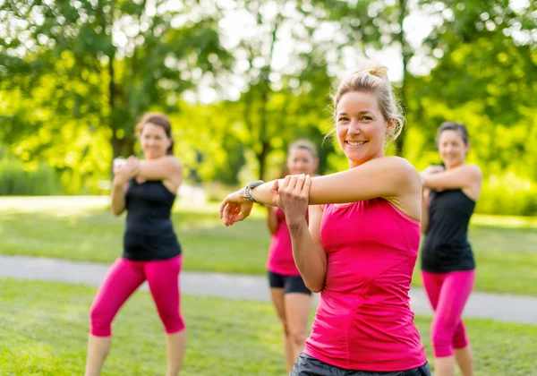Uśmiechający się trener joggingu, rozciąganie w parku th — Zdjęcie stockowe