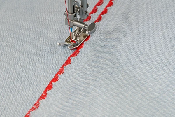 A sewing-machine makes figure seam. — Stock Photo, Image
