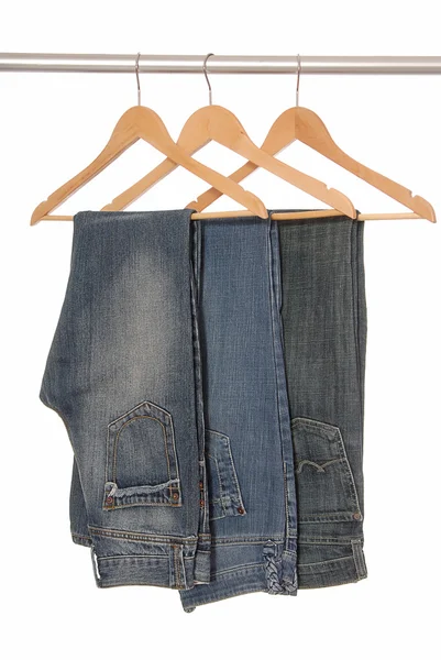 Different jeans are on hangers. — Stock Photo, Image