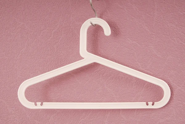 A white plastic hanger is on lilac background. — Stock Photo, Image