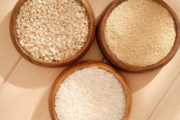 Some oatmeal, millet, rice are in woody bowls. — Stock Photo, Image