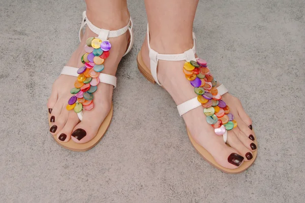 Sandálias de couro estão em pés femininos Imagem De Stock