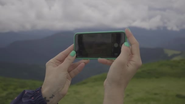 Las manos femeninas tomando fotos de hermosos paisajes de montaña en el teléfono móvil. Foto del teléfono celular fuera. — Vídeo de stock