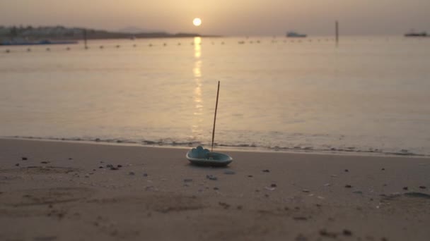 Kadidlo hořící na mořském břehu při východu slunce nad mořem. Meditační koncept. Klidné místo pro meditační cvičení. — Stock video