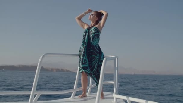 Kobieta w sukience korzystających z widokiem na morze stojących na nosie jachtu. Szczęśliwa kobieta marząca podczas rejsu na łodzi. Wycieczka morska. — Wideo stockowe