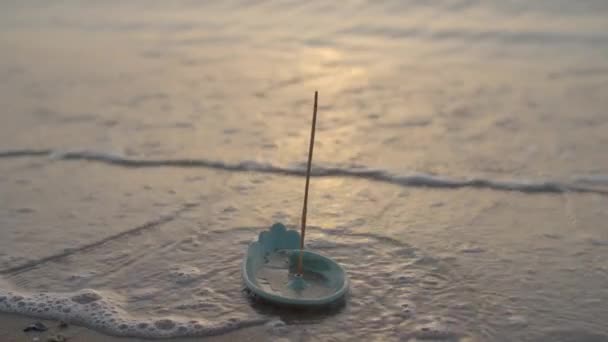 Close up of incense aroma stick burning on the sea shore. Meditation concept. Morning sea waves washing plate with aroma stick. — Stock Video