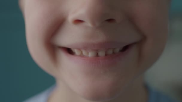 Großaufnahme eines Kindes, das mit offenem Mund lächelt. Kindermund nur angeschossen. — Stockvideo