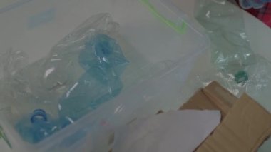 Geri dönüşümlü plastik şişeleri plastik kaplara ayıran kadın elleri. Gezegen kavramını kurtar Plastik kullanmayı bırak..