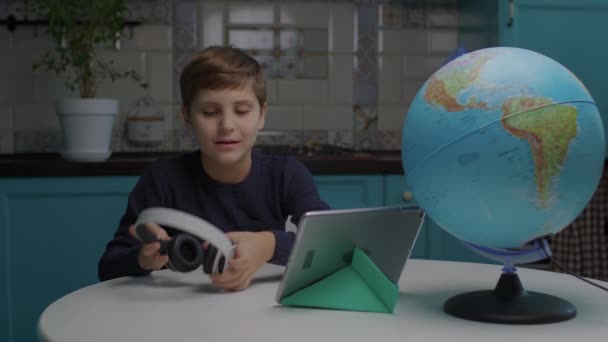 Niño de 10 años con autismo que aprende en línea con Tablet PC en casa. Sonriente autista estudiante de la escuela de casa. — Vídeos de Stock