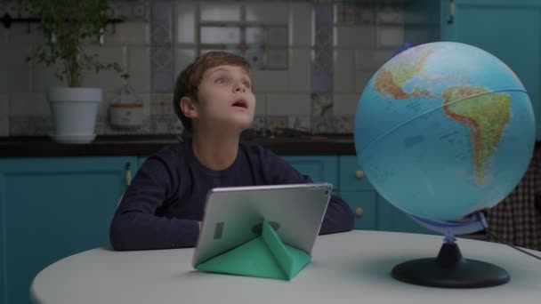 Kind mit Autismus schaut sich zu Hause um. Autistischer Junge mit Tablet-Computer in der Küche Bewusstsein für Autismus — Stockvideo