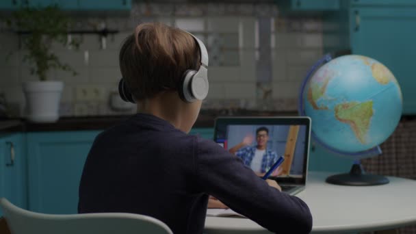 Schüler mit Kopfhörern lernen online mit afroamerikanischen männlichen Lehrern auf dem Laptop-Bildschirm. Kind lernt zu Hause im Internet. — Stockvideo