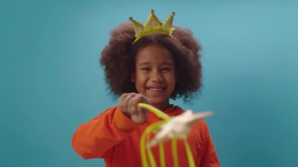 Cute African American girl in crown holding magic wand looking at camera. Smiling girl playing fairy. Let the magic begin. — Stock Video