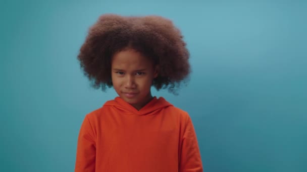 Menina afro-americana bonito balançando a cabeça negativa dizendo Não está em pé sobre fundo azul. Kid discorda movendo sua cabeça. — Vídeo de Stock