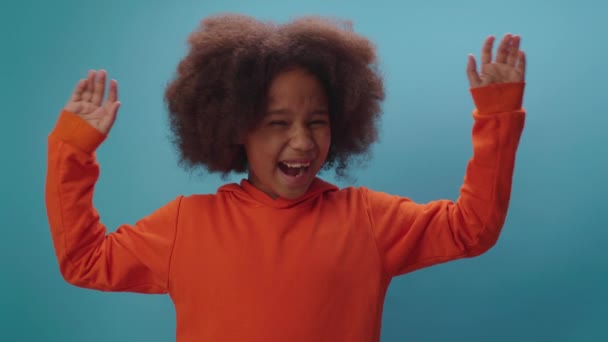 Χαρούμενη Αφρο-Αμερικανίδα που υψώνει τα χέρια της καθώς θριαμβεύει τραγουδώντας σε μπλε φόντο. Χαίρομαι που κερδίζω.. — Αρχείο Βίντεο