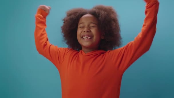 Счастливая афро-американская девушка кричит "Да" и поднимает руки вверх, как победа. Малыш счастлив победить.. — стоковое видео