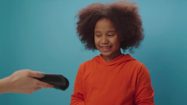 Afro-Amerikaans meisje betalen met mobiele telefoon en contactloze terminal. Happy kid met behulp van mobiele telefoon NFC betaling. — Stockvideo