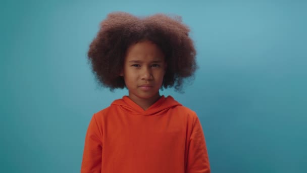 African American girl shows disagreement by shaking her head saying No standing on blue background. — Stockvideo